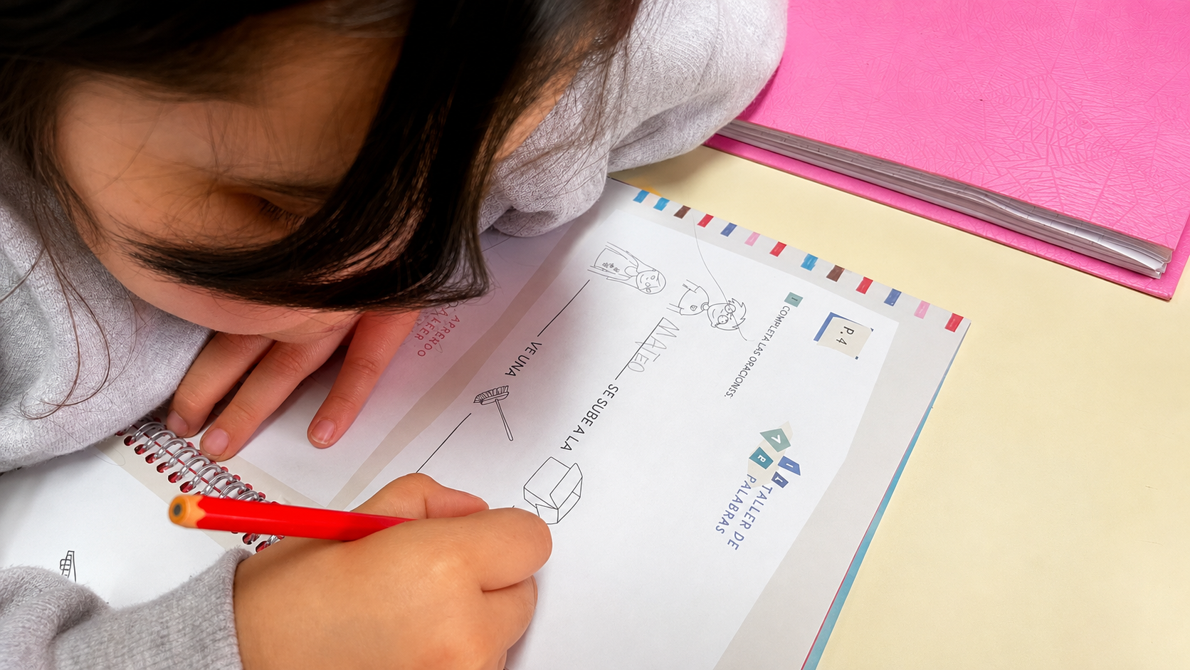 Una chica completa con lápiz una consigna de escritura en el taller de palabras